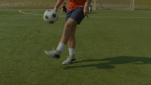 Jugador de fútbol malabares pelota de fútbol en el campo — Vídeos de Stock