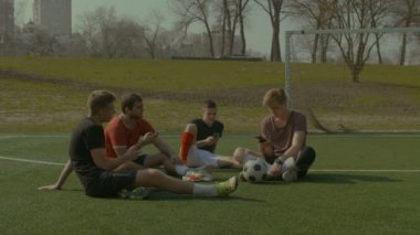 Futbol takımı futbol sahası üzerinde dinlenme akıllı telefonlar ile