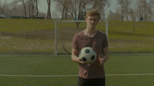 Portrét usměvavý mladík drží fotbalový míč — Stock video