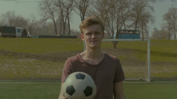 Retrato de futbolista con pelota de fútbol en el campo — Vídeos de Stock