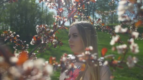 Sonriente adolescente chica en primavera jardín disfrutando de la naturaleza — Vídeo de stock