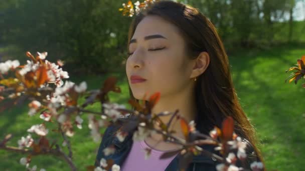 Junge Asiatin im blühenden Kirschblütengarten — Stockvideo