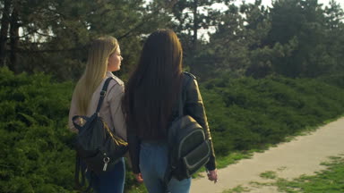 Zarif kızlar günbatımında park alanı içinde gezinme