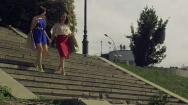 Kadınlar alışveriş torbaları merdivenlerden aşağı yürüme ile