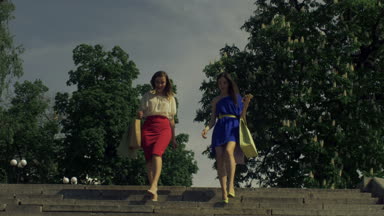 Alışveriş torbaları aşağı gidiş ile neşeli kadınlar