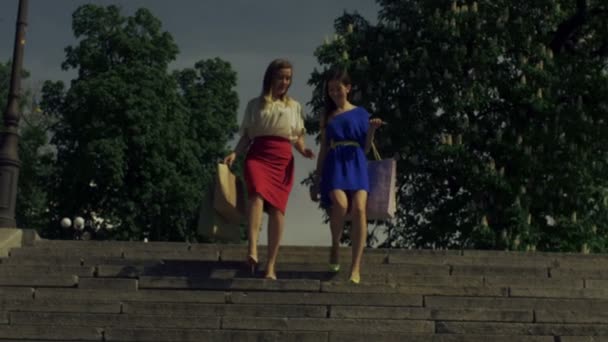 Покупательницы на высоких каблуках спускаются по лестнице — стоковое видео