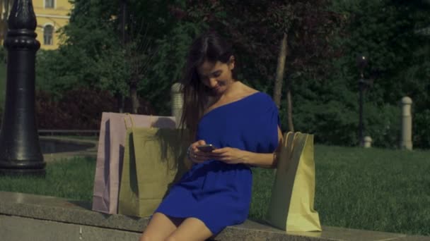 Shopper donna spensierata utilizzando lo smartphone in città — Video Stock