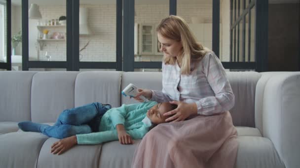 Mama mierzy temperaturę chorej dziewczyny z termometrem — Wideo stockowe