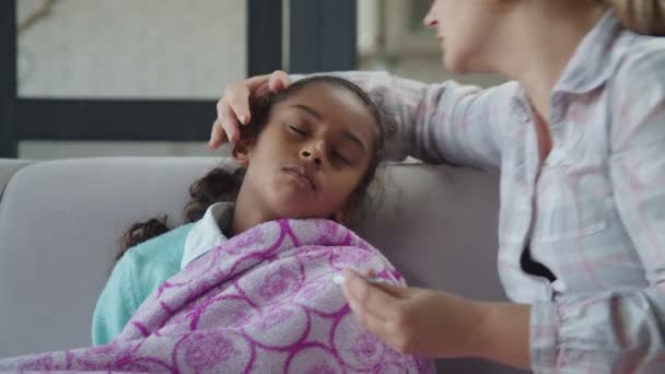 Madre cariñosa acariciando a su hija enferma en casa — Vídeos de Stock