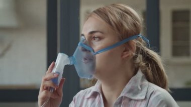 Solunum hastalıkları için nebulizör kullanan kadın.