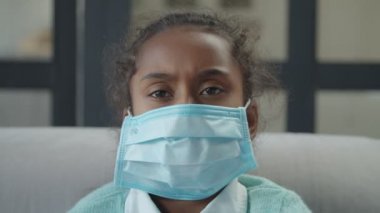 Mikrop bulaşmasın diye maske takan hasta bir kız.