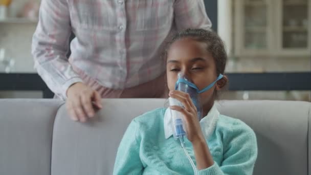 Gondoskodó anya támogatja a beteg gyermek porlasztó maszk — Stock videók