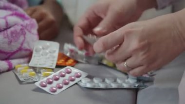 Tedavi için ilaç seçen kadın eller