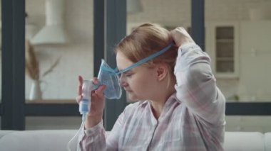 Nebulizer ile solunum tedavisi uygulayan kadın.