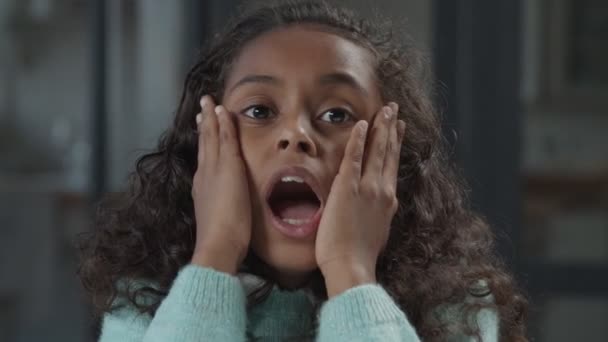 Shocked little black girl holding hands at her face — Stock Video