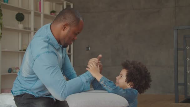 Různorodá šťastná rodina soutěží v síle doma — Stock video