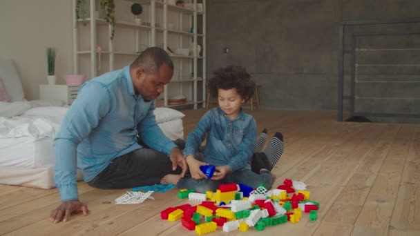 Preto pai e filho plaiyng com blocos de construção — Vídeo de Stock