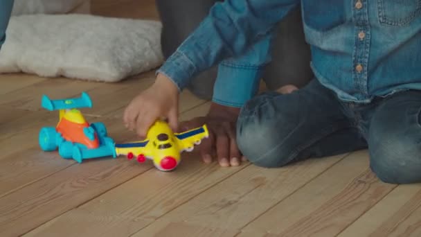 Precioso chico de raza mixta jugando con juguetes en casa — Vídeos de Stock