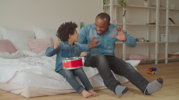 Vielfältige Familie genießt Freizeit beim Spielen der Spielzeugtrommel — Stockvideo