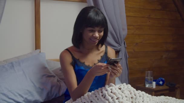 Lovely mieszane rasy kobieta tekst wiadomości w sypialni — Wideo stockowe