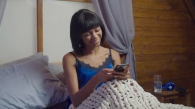 Yatakta akıllı telefonlu pozitif kadın ağı