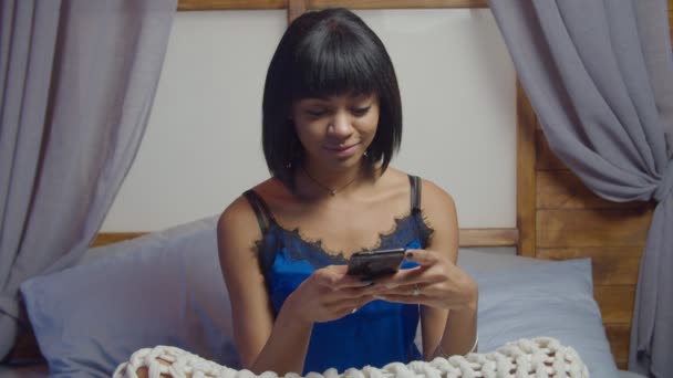 Spännande kvinna i sängen kedja online på telefon — Stockvideo