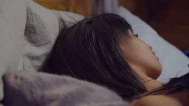 Pozitif dinlenmiş, Afro-Amerikalı, pijamalı, çekici genç bir kadın sabahın erken saatlerinde uyanıp neşeli, dostane bir gülümsemeyle mutluluğu, neşeyi ve sağIığı ifade ediyor..
