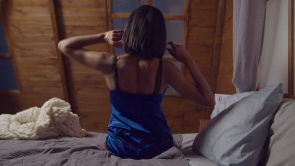 Mujer elegante estirándose en la cama después de despertarse — Vídeos de Stock