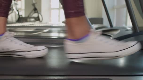 Γυναικεία πόδια πατώντας σε λειτουργία μηχάνημα διάδρομο — Αρχείο Βίντεο