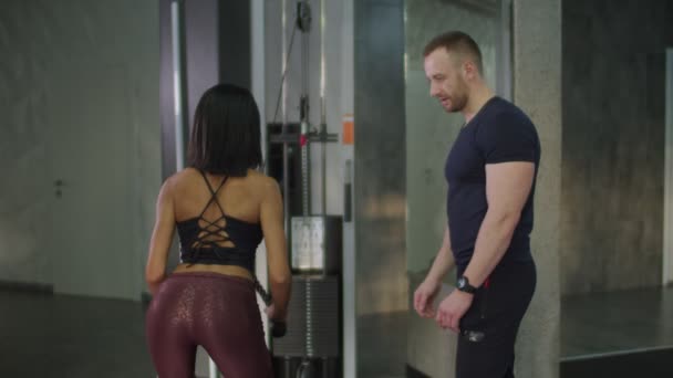 Kvinna gör rep nedtryckningar för triceps med tränare — Stockvideo