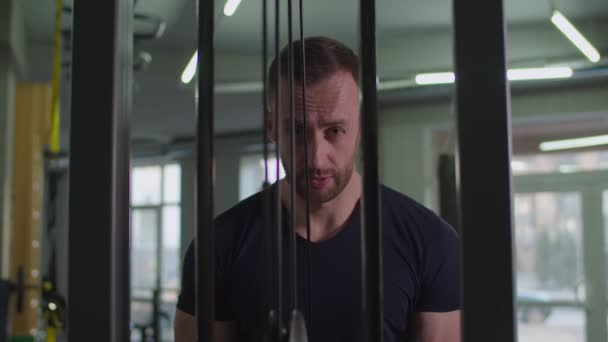 Muž cvičení triceps tlačení na lano kabel stroje — Stock video