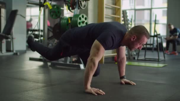 Man training buikspieren met vering trx riemen in de sportschool — Stockvideo