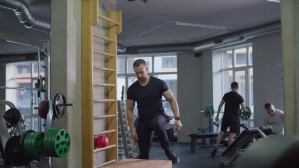 Fitter Athlet macht Kniebeugen auf Holzkiste — Stockvideo
