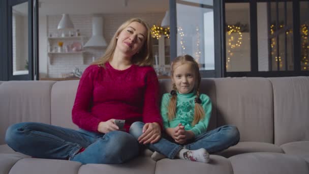 Anya és lánya otthon a kanapén tévénézés — Stock videók