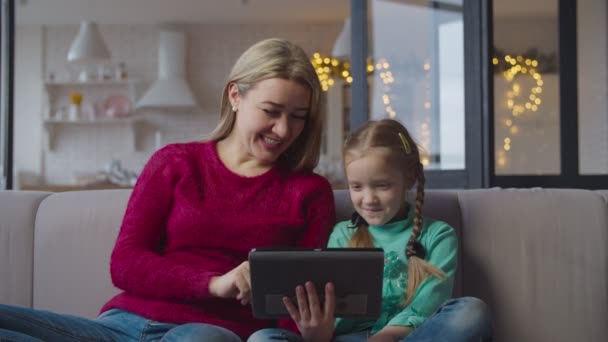 Madre y niña en el sofá de red con la tableta de PC — Vídeo de stock