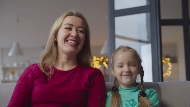 Happy mom and cute girl watching tv show at home — 비디오