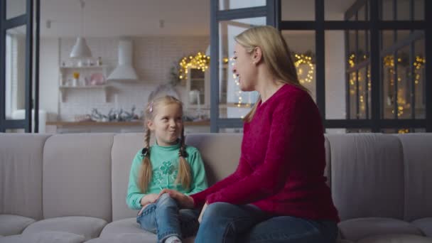 Liebevolle Mutter und kleine Tochter beim Binden auf dem Sofa — Stockvideo