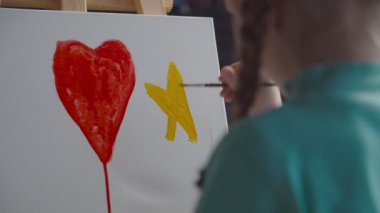 Renkli resimlerle resim yazan küçük bir ressam.