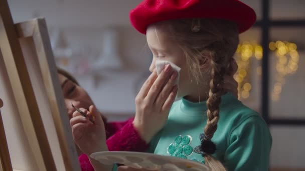 Moeder vegen gezicht van kleine meisje besmeurd met verf — Stockvideo