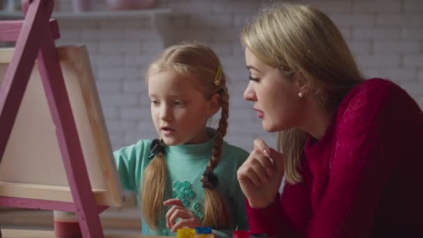 Mutter und kleines Mädchen tauschen sich über Malerei aus — Stockvideo