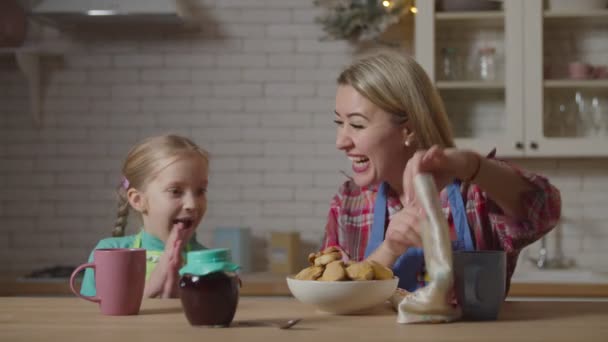 ママと子供がキッチンで自家製クッキーを食べる — ストック動画