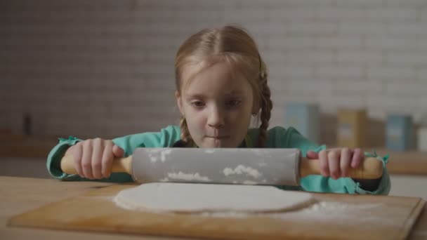 Cute little girl rolling out dough with rolling pin — 비디오