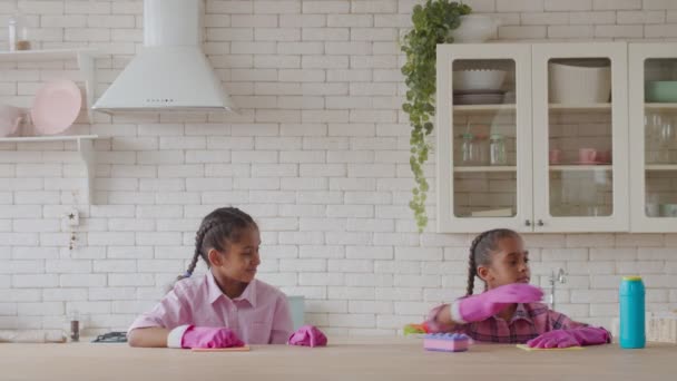 Маленькі сестри допомагають мамі з прибиранням на кухні — стокове відео