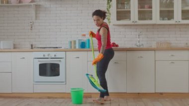 Temizlik sırasında dans eden ve şarkı söyleyen kadın.