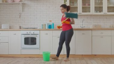 Heyecanlı Afrikalı kadın paspasla dans ediyor.