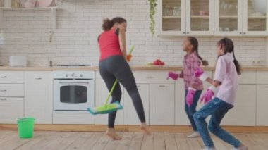Çocuklu neşeli bir aile temizlik sırasında eğleniyor.
