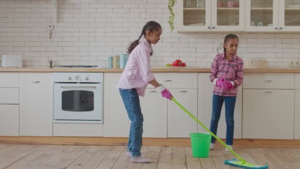 Servicio de limpieza mestiza hermanas frotando por el piso — Vídeo de stock