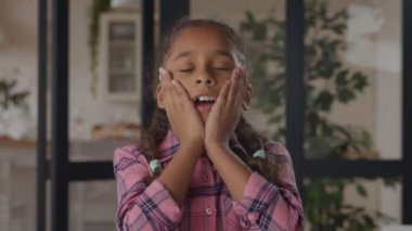 Şaşırmış küçük kız ellerinin yanaklarını tutuyor.