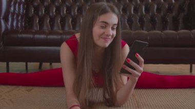 Güzel bir kadın oturuyor ve telefonda konuşuyor.