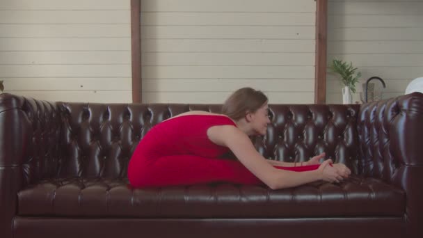 Ευέλικτη γυναίκα κάνει γιόγκα asana κάθεται προς τα εμπρός στροφή — Αρχείο Βίντεο